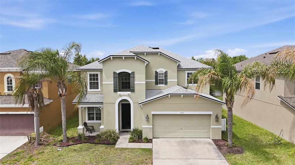 1765 Strathmore Circle Mount Dora, FL 32757 - Photo 6 of 51 a front view of a house with a yard and garage