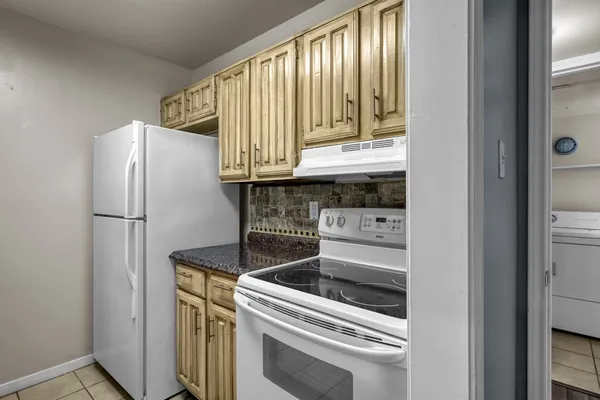 a kitchen with a refrigerator and a stove