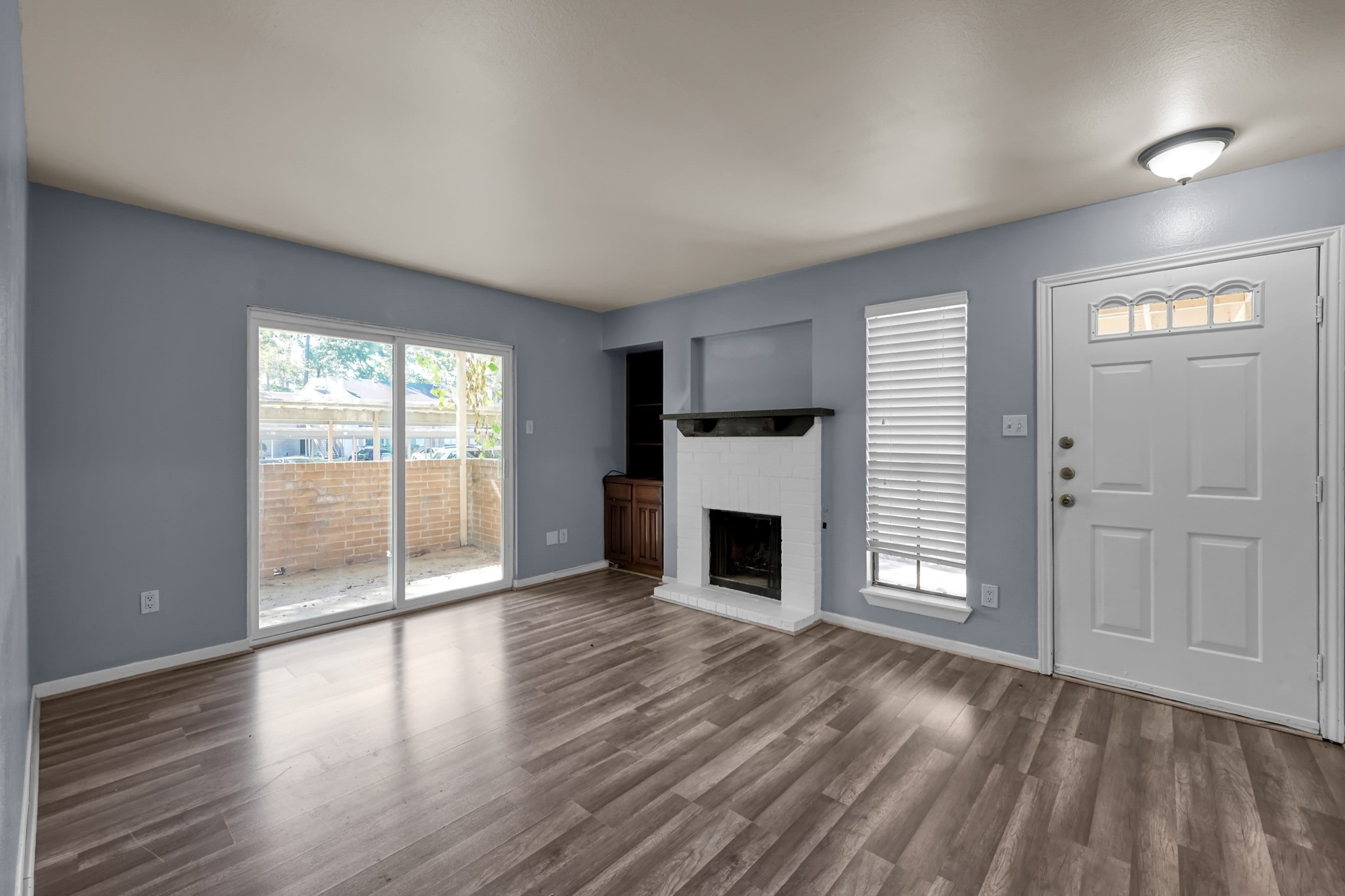 3500 Tangle Brush Drive, Unit 40 Spring, TX 77381 - Photo 6 of 19 an empty room with wooden floor a fireplace and windows