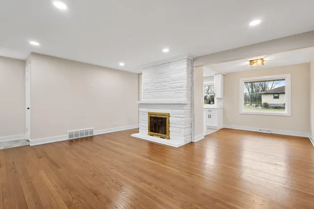 a view of an empty room with a fireplace and a window
