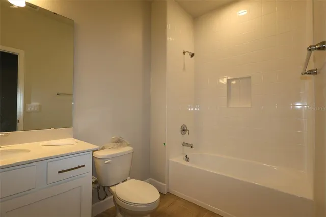 a bathroom with a granite countertop toilet a sink and bathtub