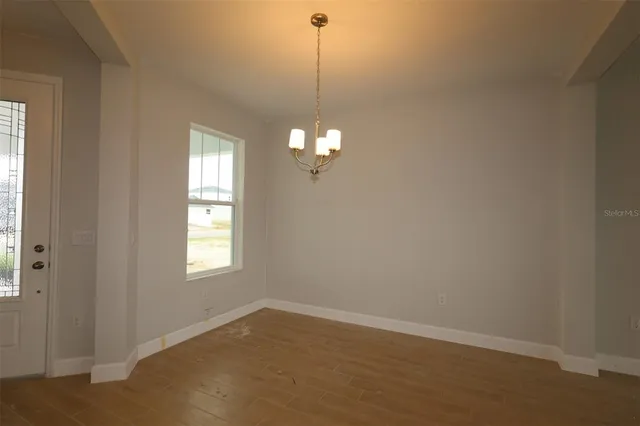 a view of a room with window and hardwood floor