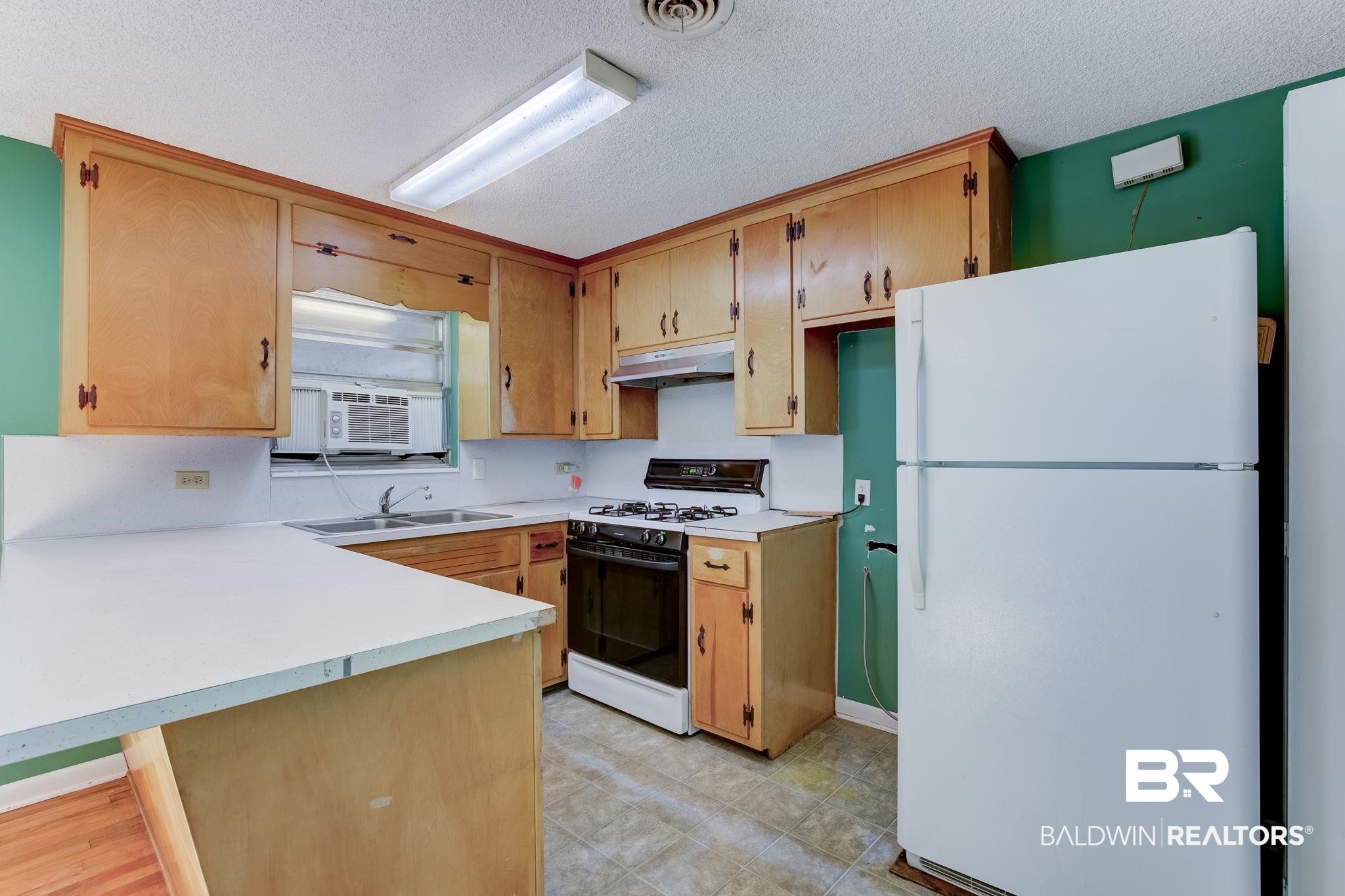 606 East Myrtle Avenue Foley, AL 36535 - Photo 23 of 24 Kitchen featuring white appliances, cooling unit, sink, a textured ceiling, and kitchen peninsula