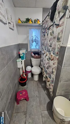 a bathroom with a toilet and a shower curtain
