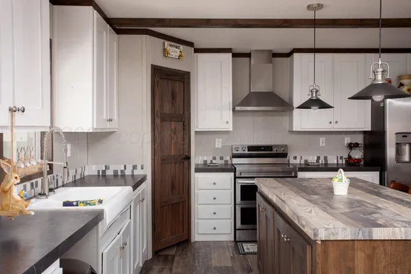 a kitchen with stainless steel appliances granite countertop a sink stove and cabinets