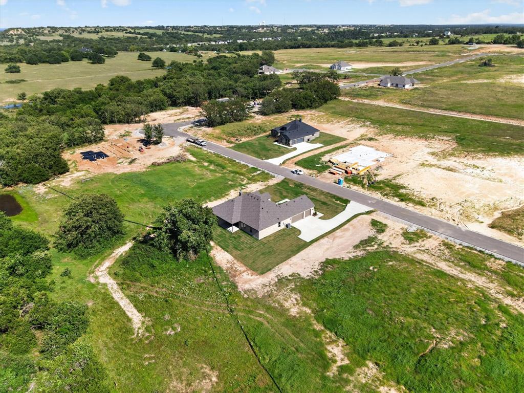 409 Mcalpine Springtown, TX 76082 - Photo 36 of 38 Aerial perspective showcasing a developing residential area with established homes and lots under construction