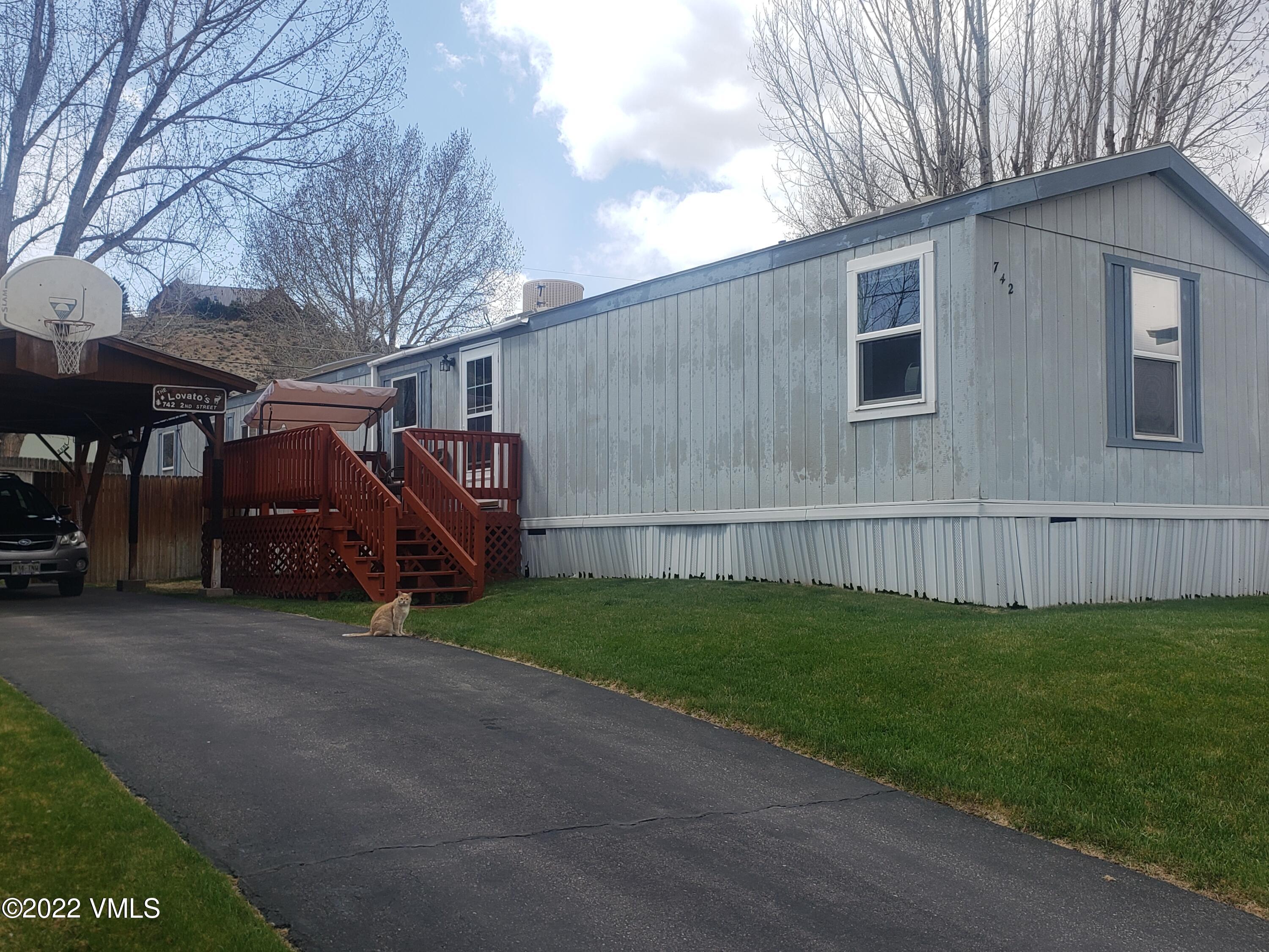 a view of a house with backyard and trees