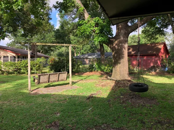 a view of a backyard with table and chairs and a large tree