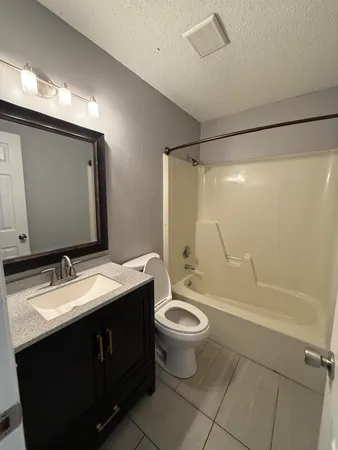 a bathroom with a double vanity sink toilet mirror and shower