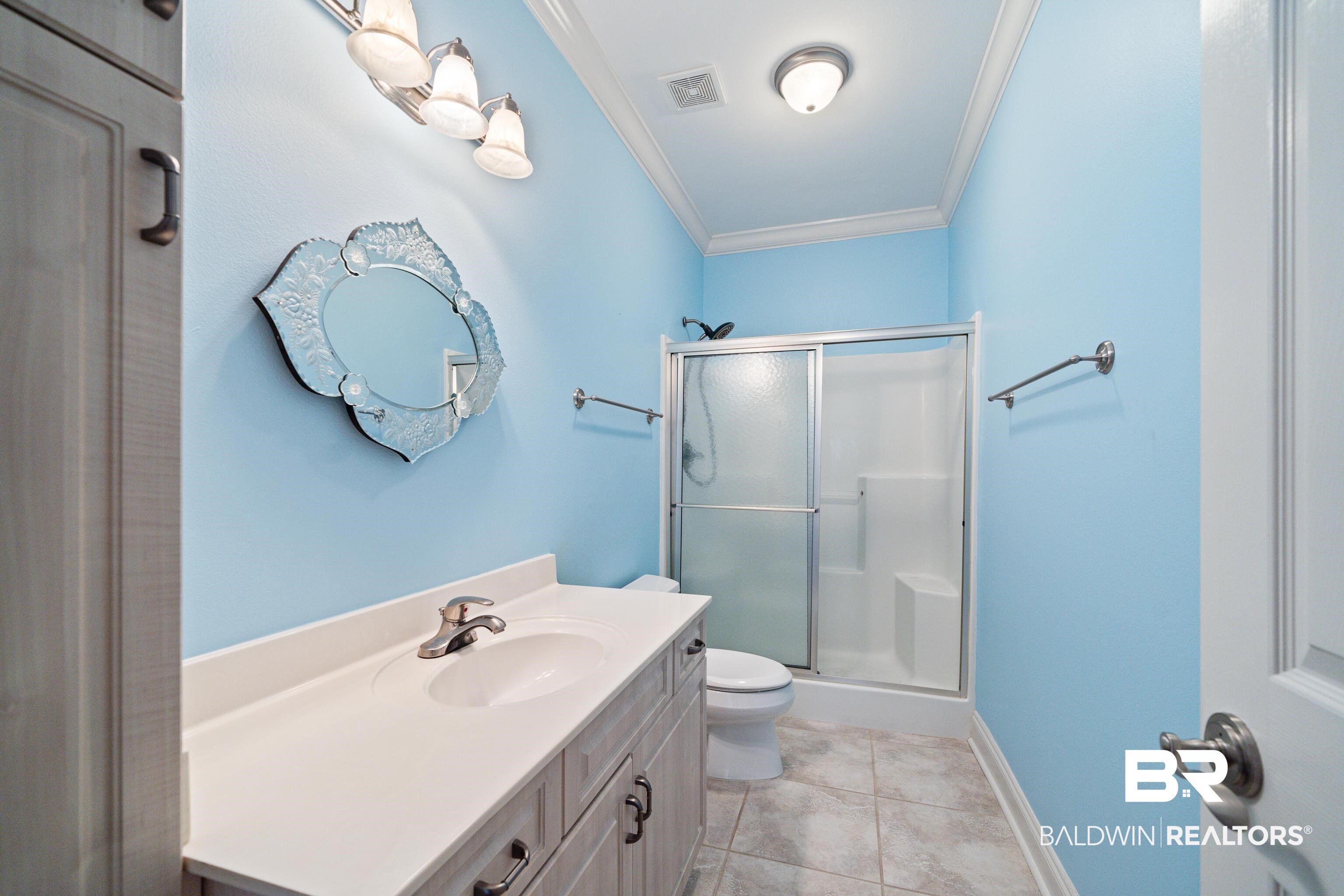 404 Savannah Lane Foley, AL 36535 - Photo 20 of 29 Bathroom with visible vents, toilet, ornamental molding, tile patterned floors, and a shower stall