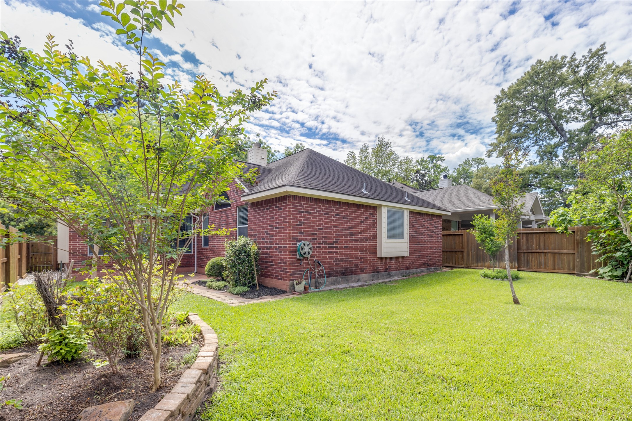 20710 Water Point Trail Humble, TX 77346 - Photo 22 of 29 This inviting backyard, viewed from the back corner, has a lush green lawn and tasteful landscaping, offering a serene and private space perfect for relaxation or outdoor gatherings.