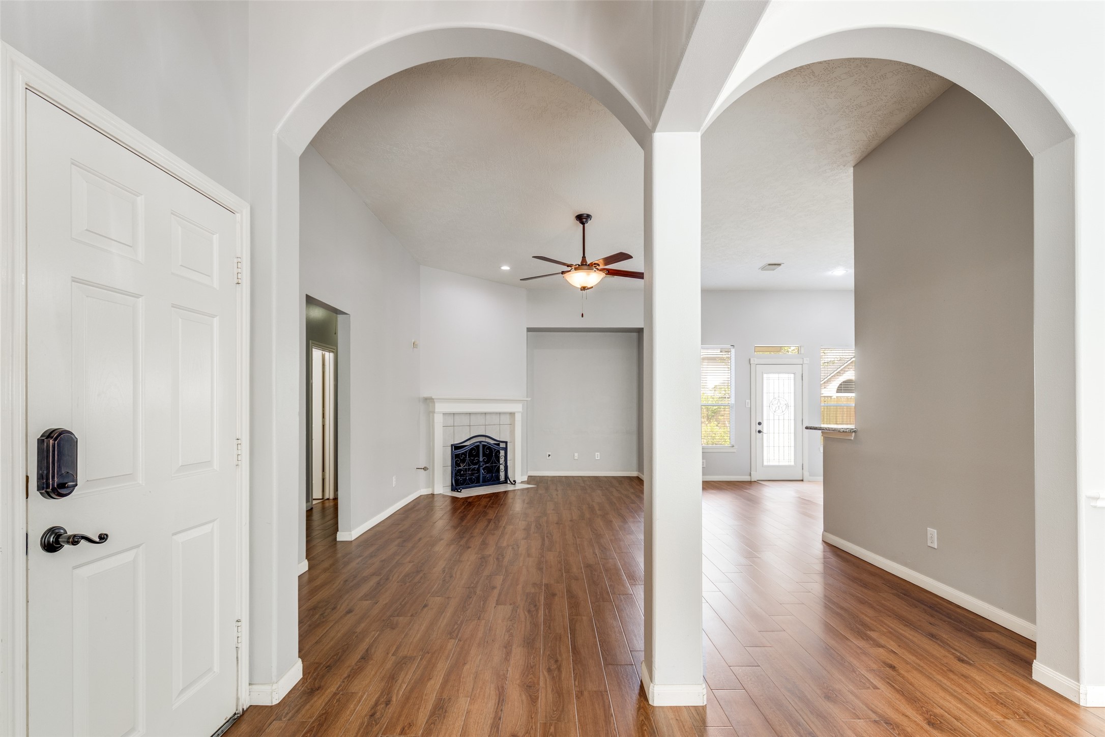20710 Water Point Trail Humble, TX 77346 - Photo 4 of 29 Stepping into this home, you are greeted by elegant archways, where warm wood floors and a cozy fireplace create a welcoming ambiance.