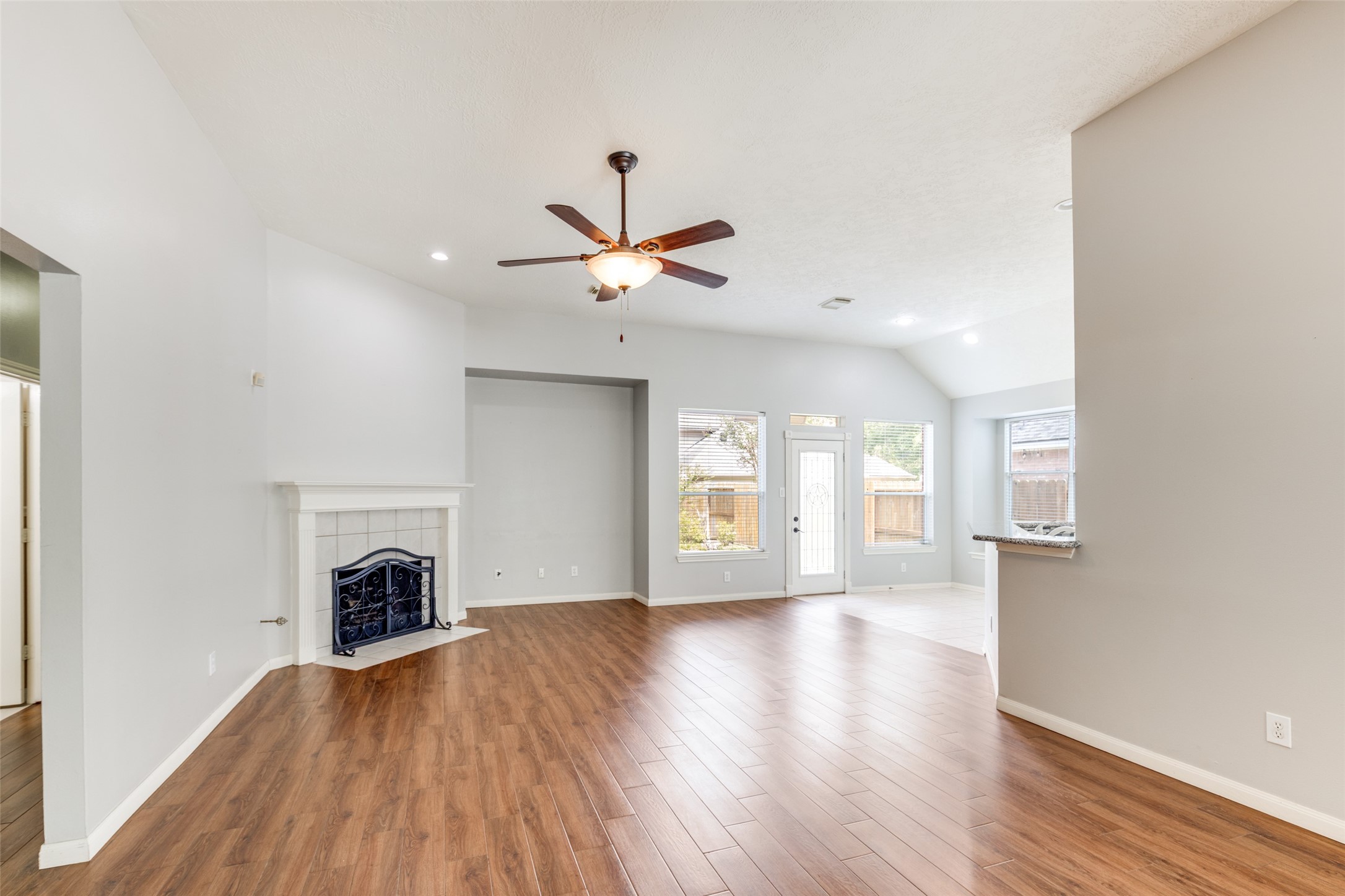20710 Water Point Trail Humble, TX 77346 - Photo 7 of 29 Step into a spacious living room with timeless wood flooring, a cozy fireplace, and abundant natural light from the abundance of windows.