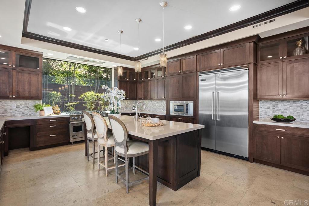 1159 Larksong Lane Encinitas, CA 92024 - Photo 18 of 68 a kitchen with stainless steel appliances granite countertop a refrigerator a sink a stove a dining table and chairs