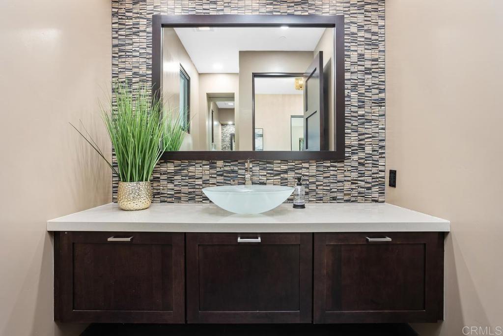 1159 Larksong Lane Encinitas, CA 92024 - Photo 25 of 68 a bathroom with a sink a mirror and a potted plant