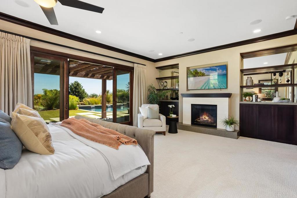 1159 Larksong Lane Encinitas, CA 92024 - Photo 27 of 68 a bedroom with a large bed and a fireplace