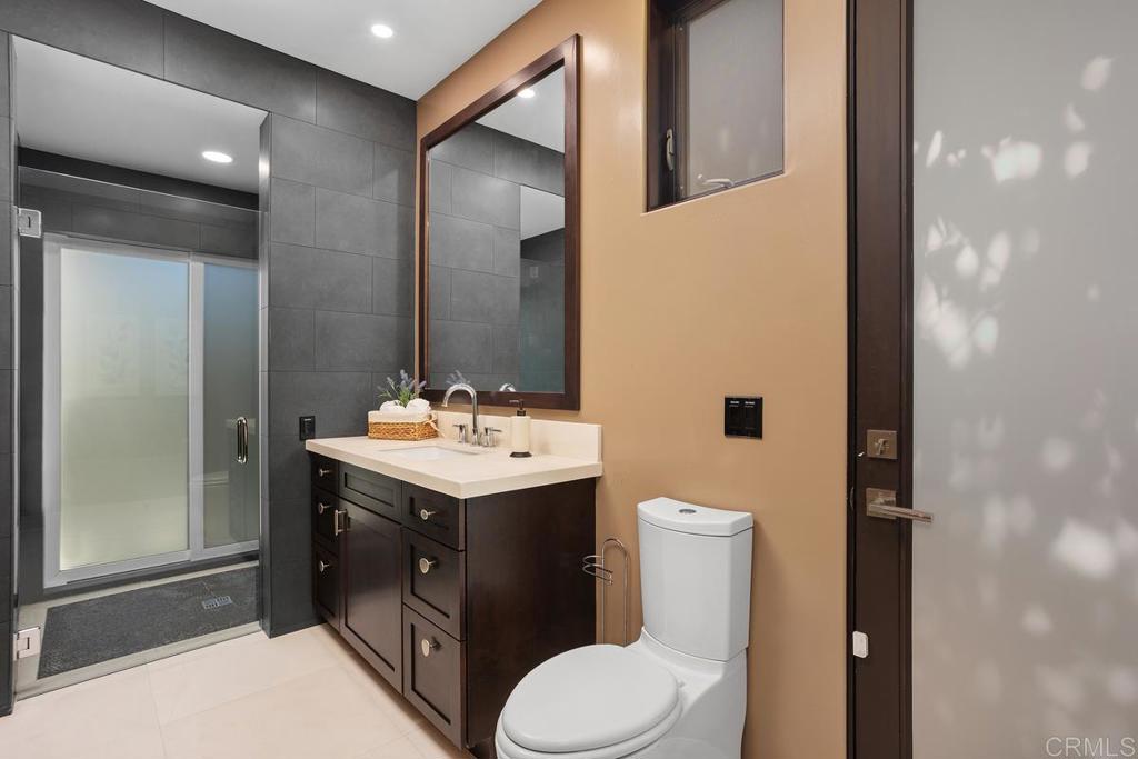 1159 Larksong Lane Encinitas, CA 92024 - Photo 34 of 68 a bathroom with a toilet sink and mirror