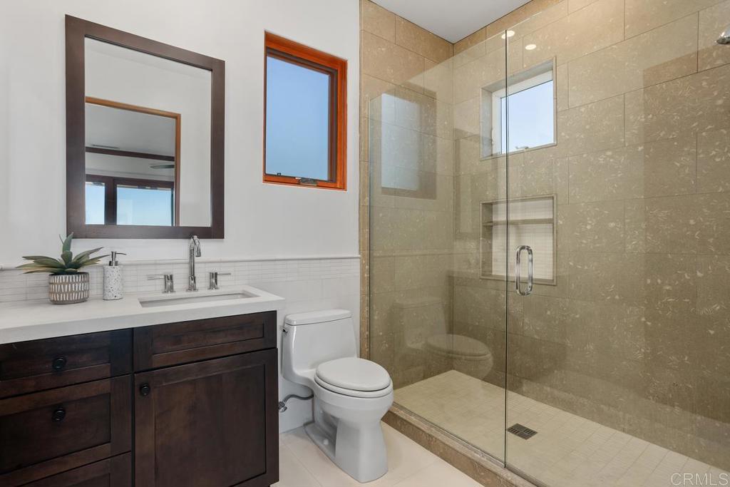 1159 Larksong Lane Encinitas, CA 92024 - Photo 45 of 68 a bathroom with a shower sink vanity mirror and toilet