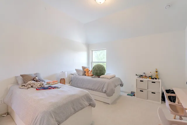a bedroom with two beds and a white cabinet