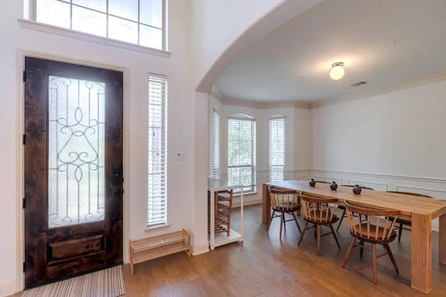 a view of a a dining room with furniture window and wooden floor