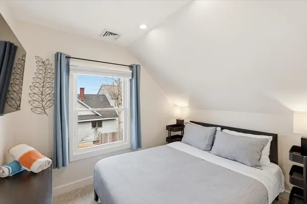 a bedroom with a bed and painting on the wall