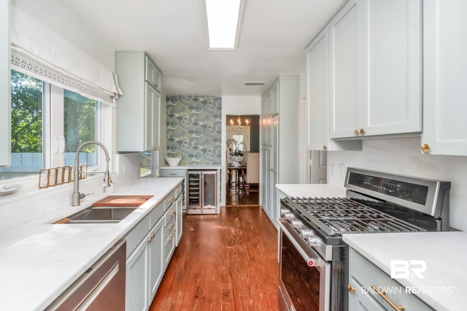 18 Princess Anne Road Mobile, AL 36608 - Photo 12 of 41 Kitchen featuring appliances with stainless steel finishes, dark wood-type flooring, wine cooler, wallpapered walls, and light stone counters
