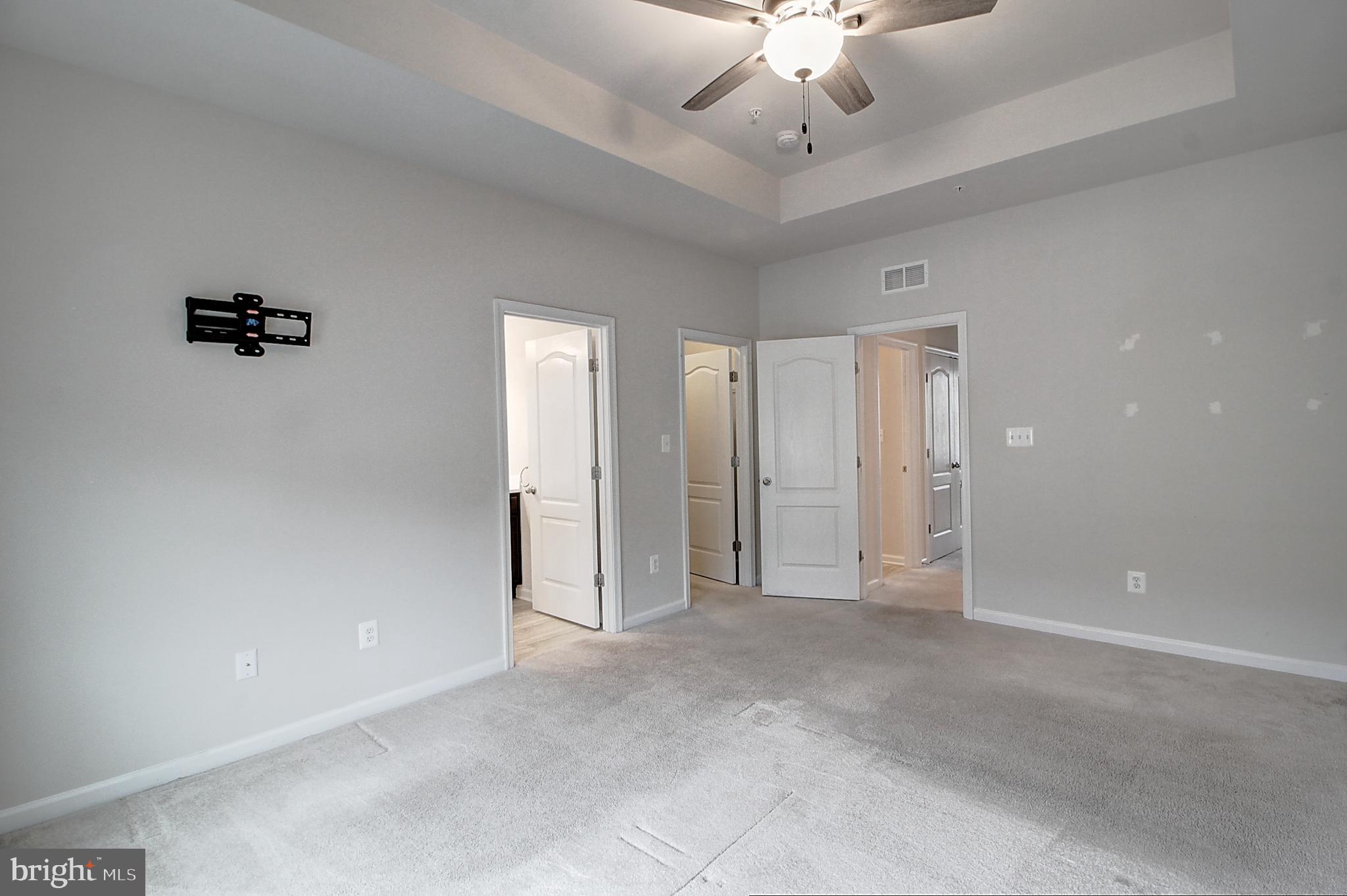 304 Spring Bank Way Frederick, MD 21701 - Photo 19 of 27 wooden floor in an empty room with a chandelier fan