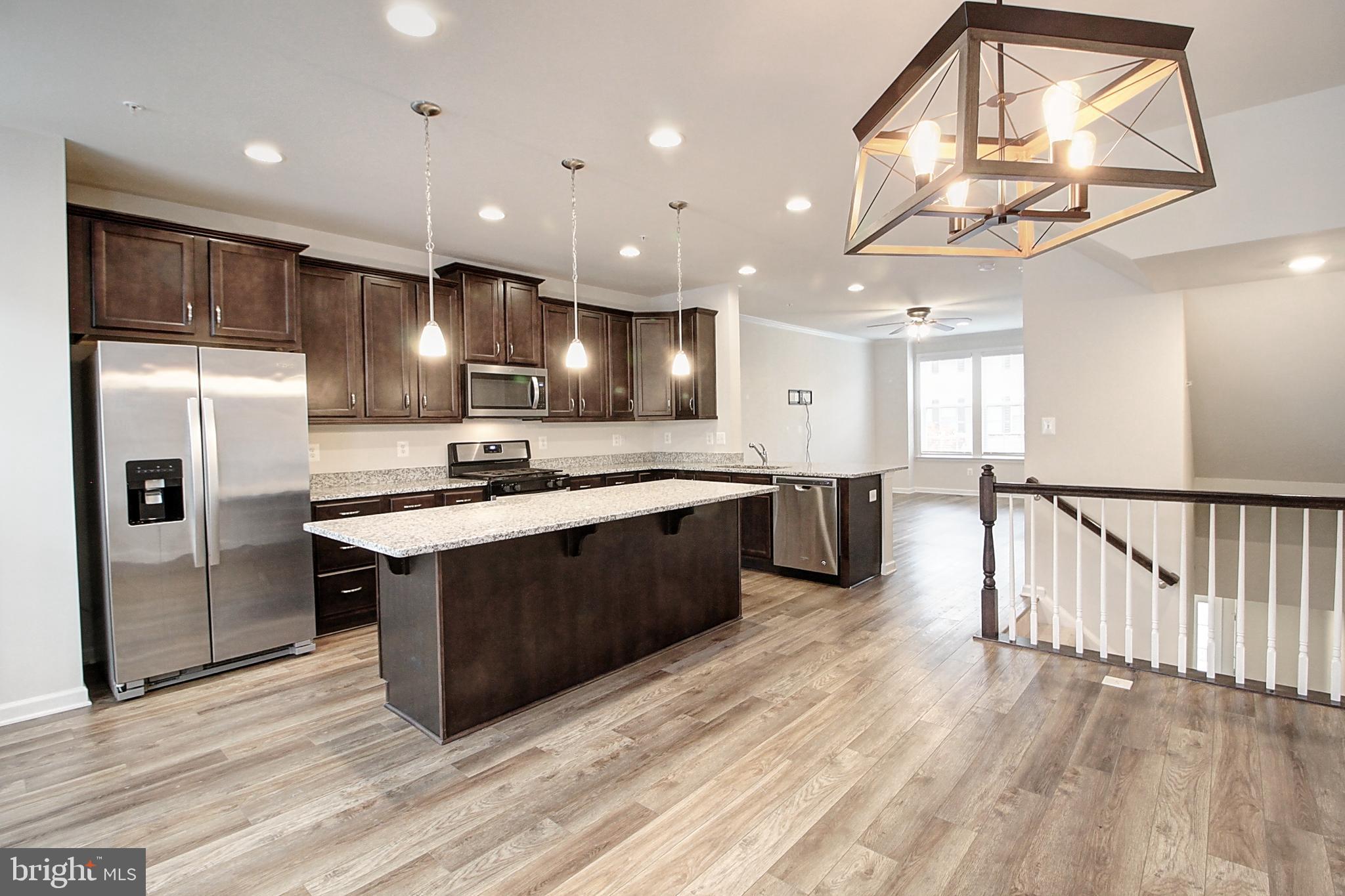 304 Spring Bank Way Frederick, MD 21701 - Photo 3 of 27 a large kitchen with a large counter top a sink stainless steel appliances and cabinets