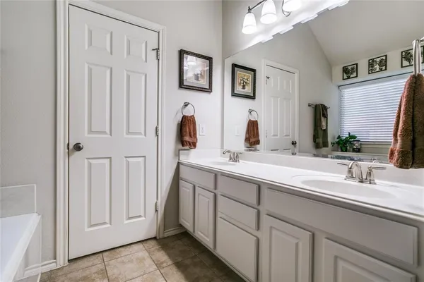 a bathroom with a double vanity sink and a mirror