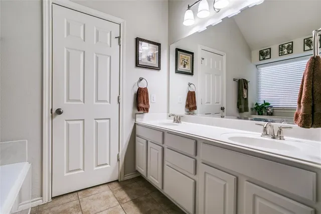 a bathroom with a double vanity sink and a mirror