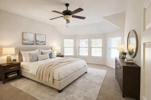 a spacious bedroom with a large bed a chandelier and windows