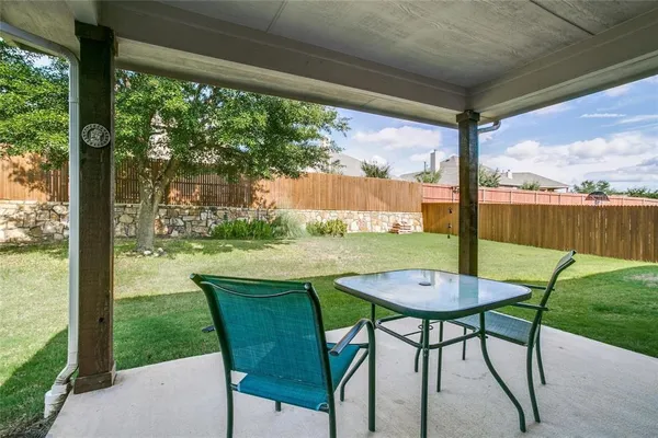 a view of an outdoor dining space with a table and chairs