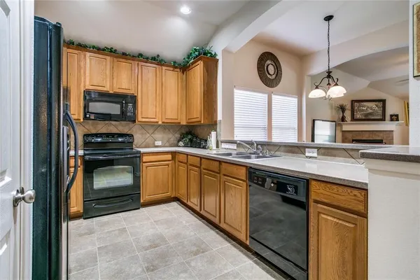 a kitchen with granite countertop a stove a sink and a microwave