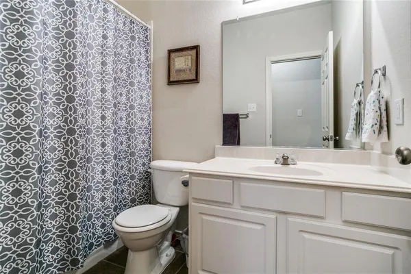 a bathroom with a toilet sink vanity and mirror