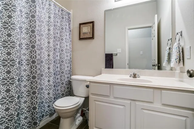 a bathroom with a toilet sink vanity and mirror
