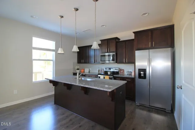 a kitchen with kitchen island a sink stainless steel appliances and window