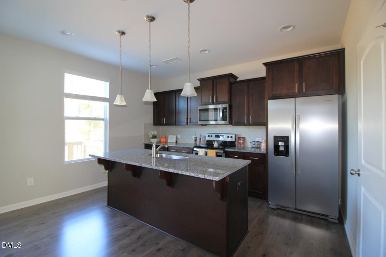 349 Great Northern Station Apex, NC 27502 - Photo 6 of 20 a kitchen with kitchen island a sink stainless steel appliances and window