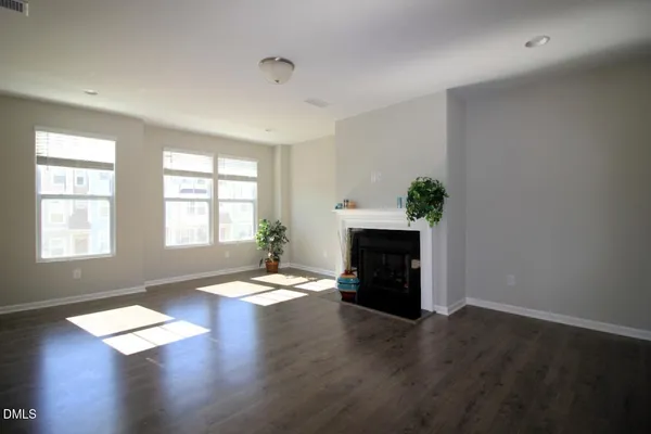 an empty room with windows and a fireplace