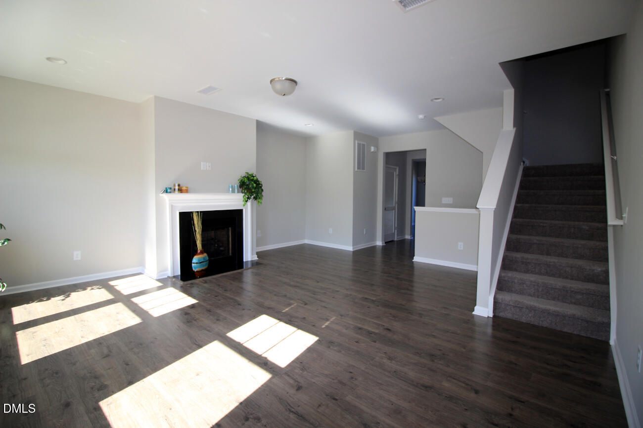 349 Great Northern Station Apex, NC 27502 - Photo 10 of 20 a view of a livingroom with wooden floor and a fireplace