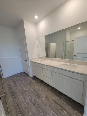 a spacious bathroom with a double vanity sink and a mirror