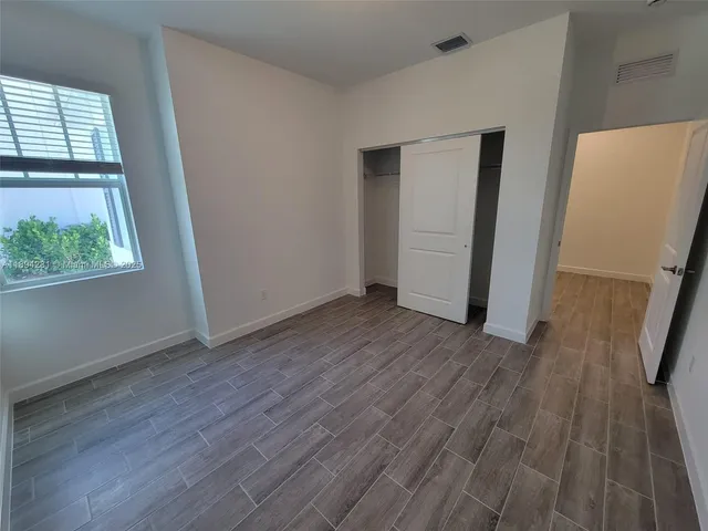 an empty room with wooden floor and a window