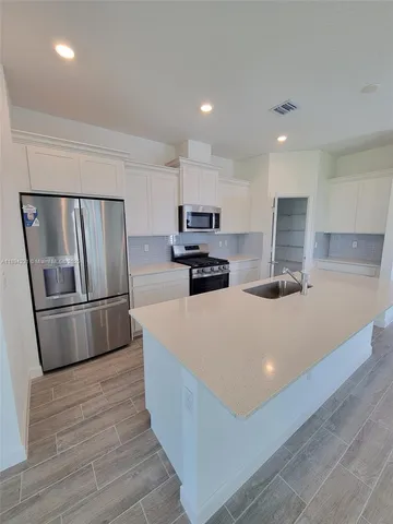 a kitchen with stainless steel appliances a refrigerator sink and microwave