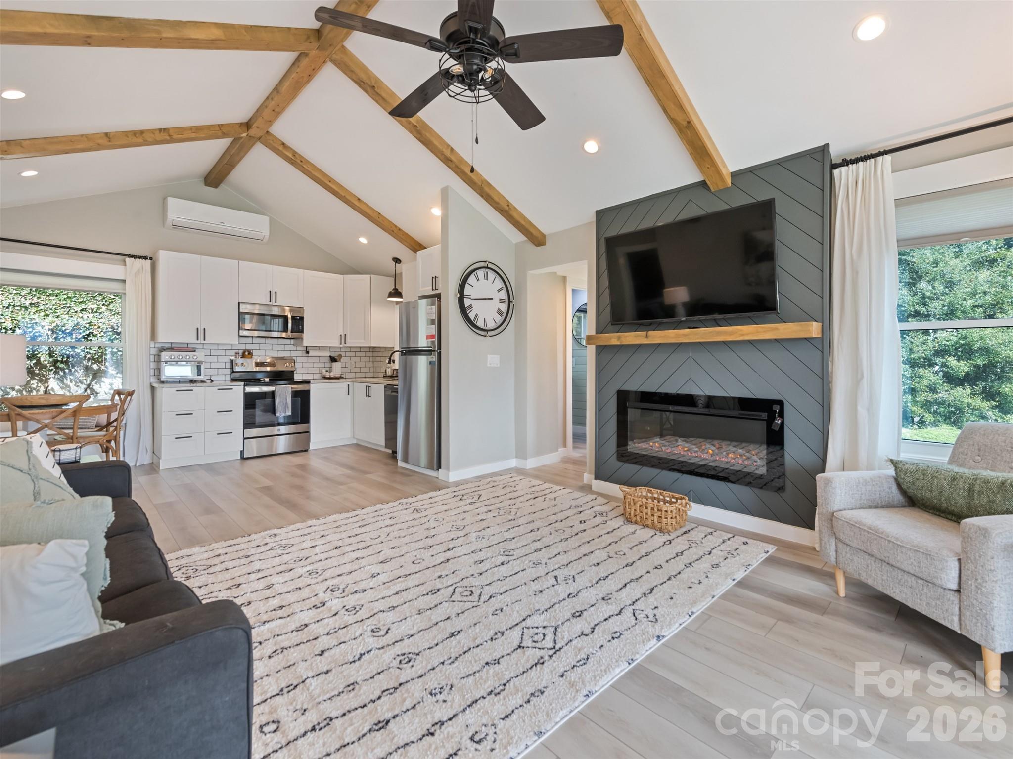 659 Golf Course Road Waynesville, NC 28786 - Photo 12 of 34 a living room with furniture a flat screen tv and a fireplace
