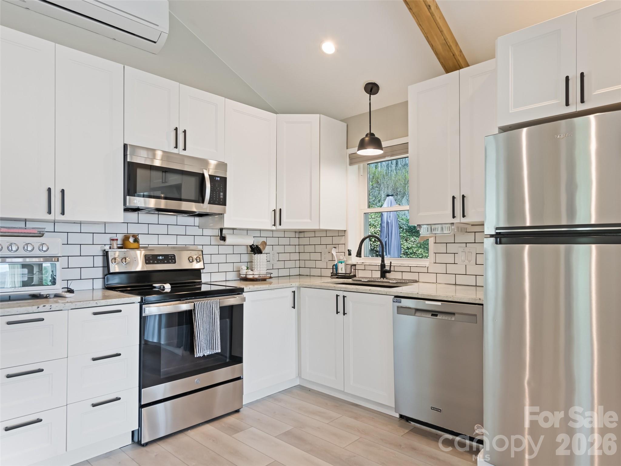 659 Golf Course Road Waynesville, NC 28786 - Photo 14 of 34 a kitchen with refrigerator a microwave a sink and cabinets