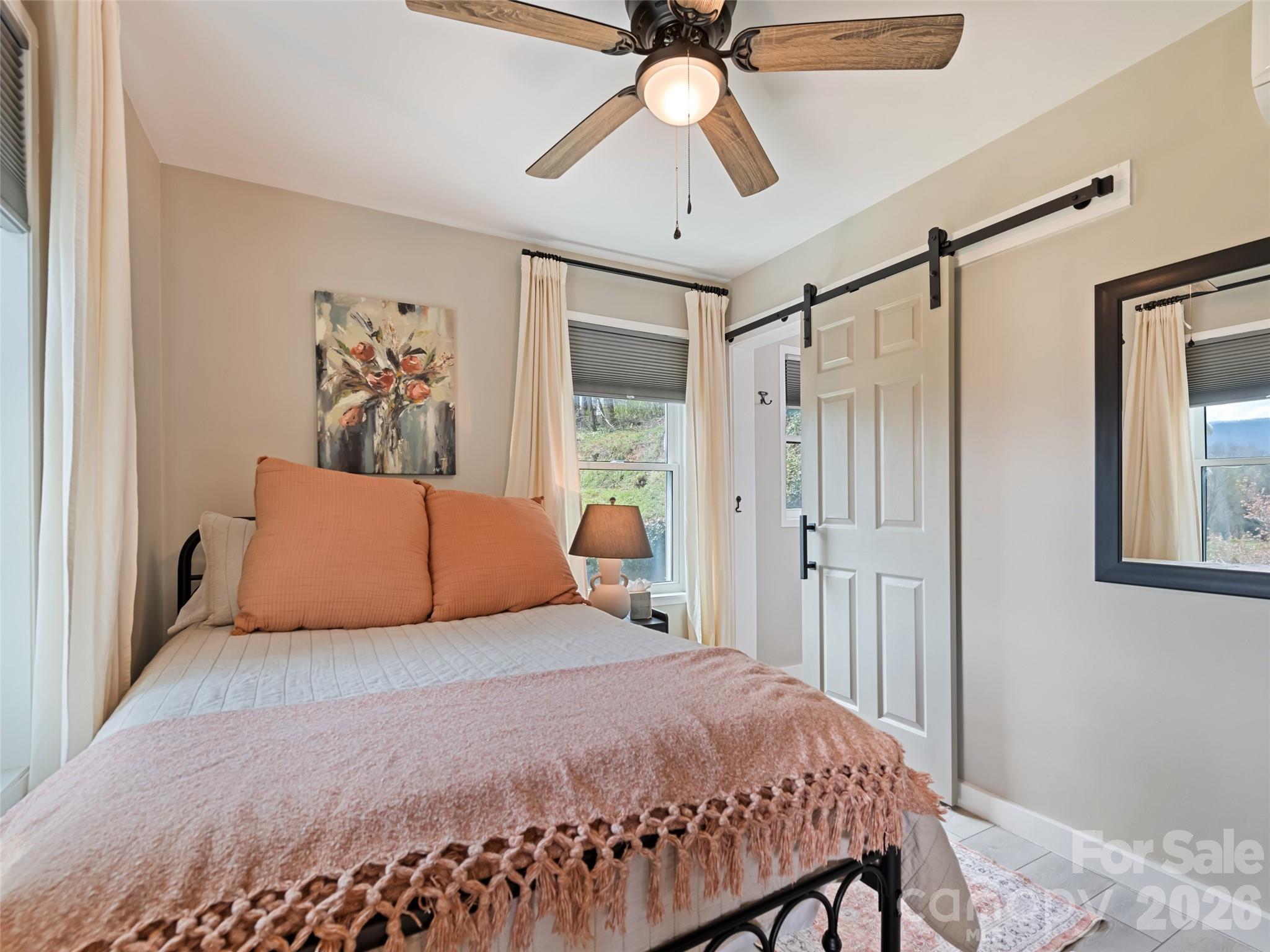 659 Golf Course Road Waynesville, NC 28786 - Photo 22 of 34 a bedroom with a large bed and a chandelier