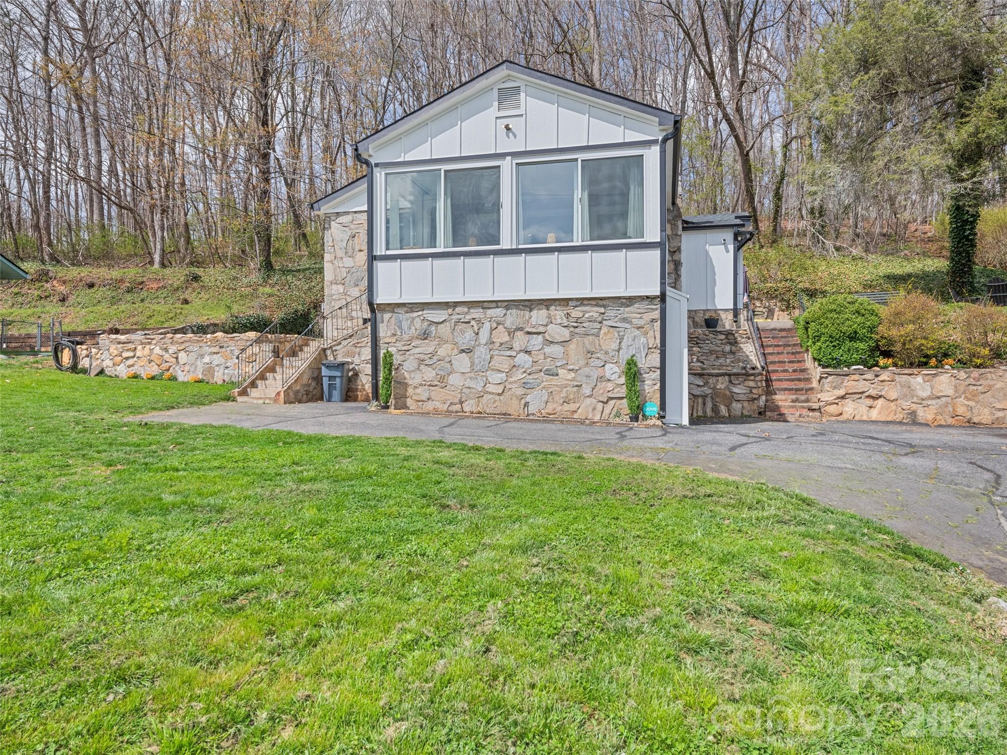 659 Golf Course Road Waynesville, NC 28786 - Photo 5 of 34 a front view of a house with garden