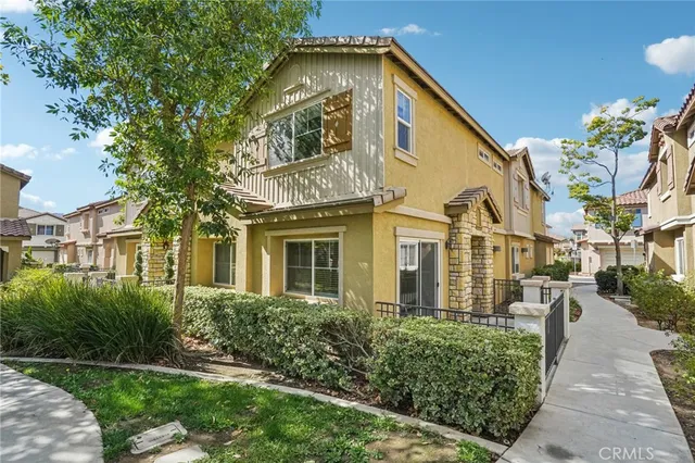 a view of a white house with a large windows and a yard