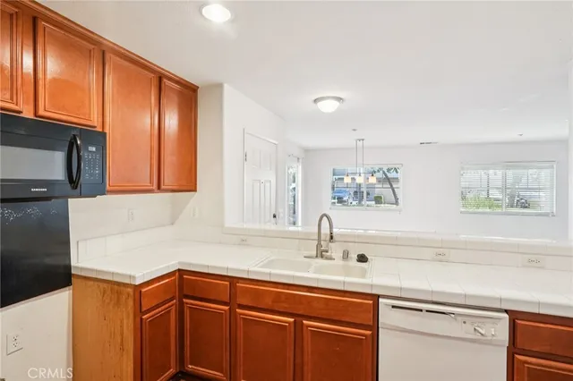 a kitchen with stainless steel appliances granite countertop a sink and cabinets with wooden floor