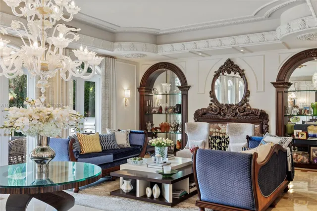 a living room with patio furniture and a chandelier