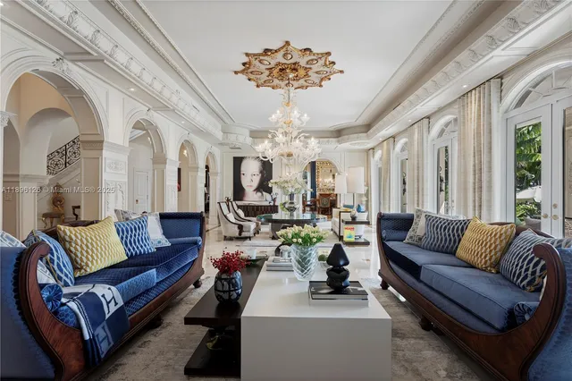 a living room with patio furniture and a chandelier